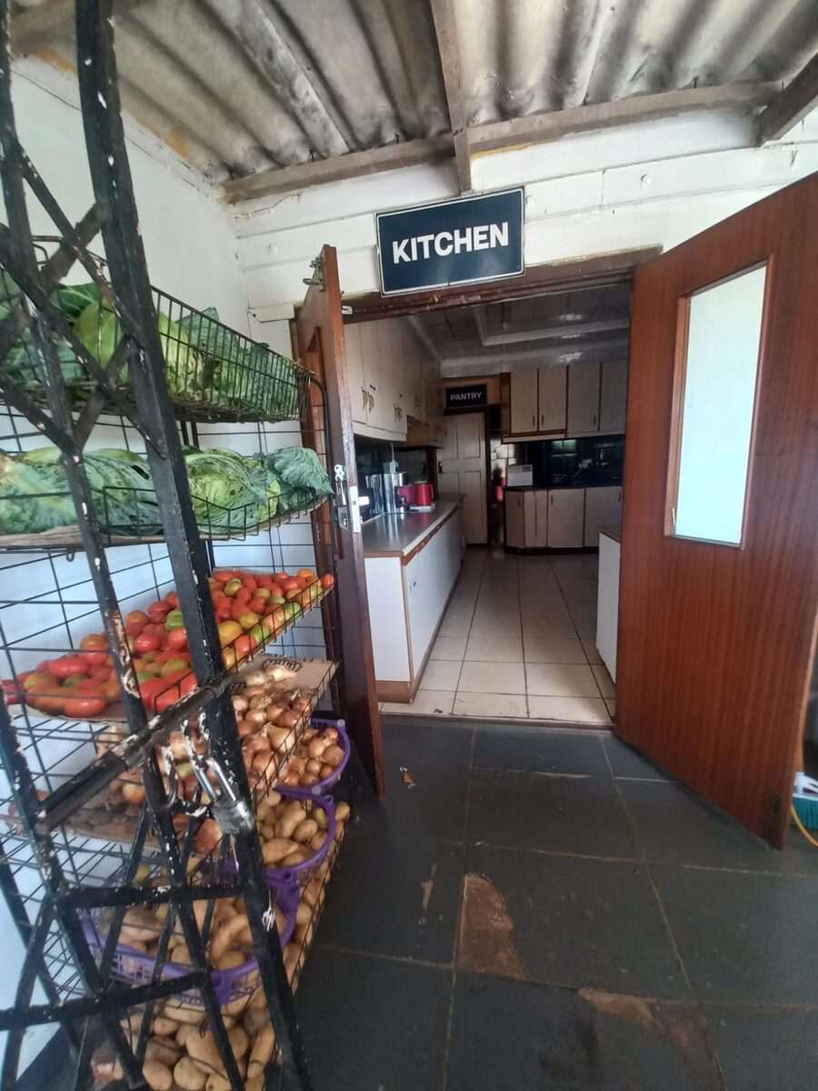 Kitchen entrance at the care centre with fresh vegetables stacked on shelves
